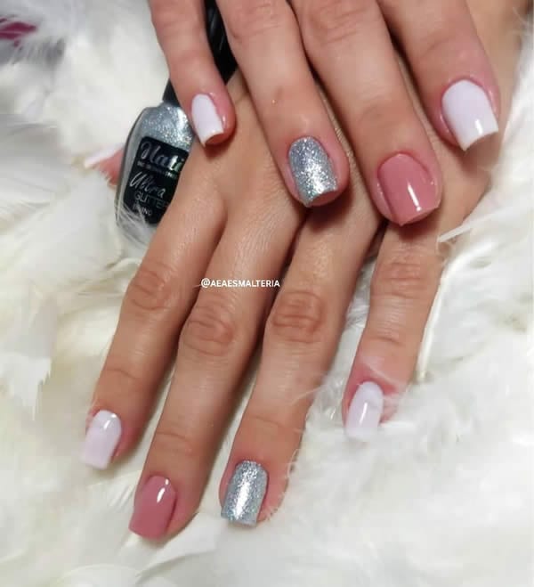 unhas decoradas curtas e quadradas, com dois dedos de branco, um de rosa nude e ouro de glitter prata