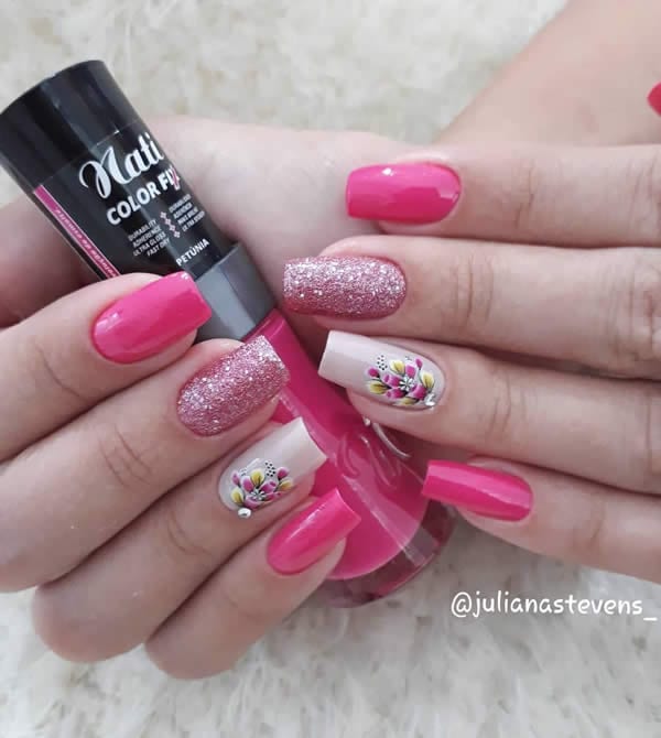 unhas decoradas com três unhas derosa pink, uma unha com glitter rosa e uma unhas com branco e flores