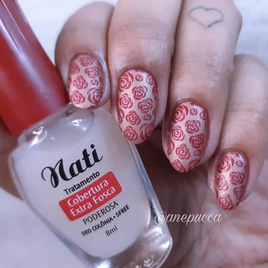 esmaltação fosca com base nude cintilante e flores vermelhas carimbadas